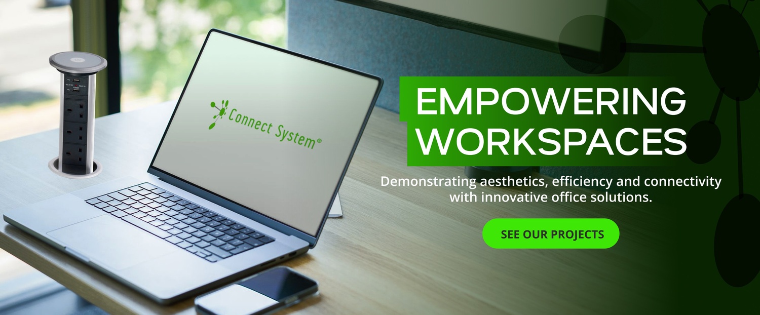 Laptop on a desk displaying Connect System logo with a bold green banner reading 'Empowering Workspaces' and a 'See Our Projects' button, promoting office solutions.